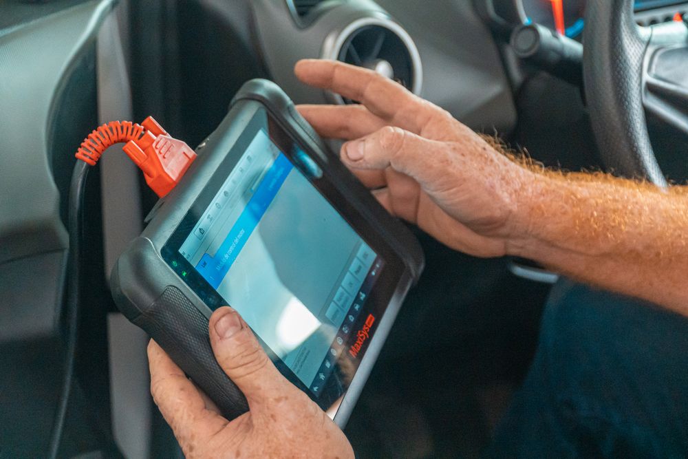 A technician running diagnostics with a scan tool