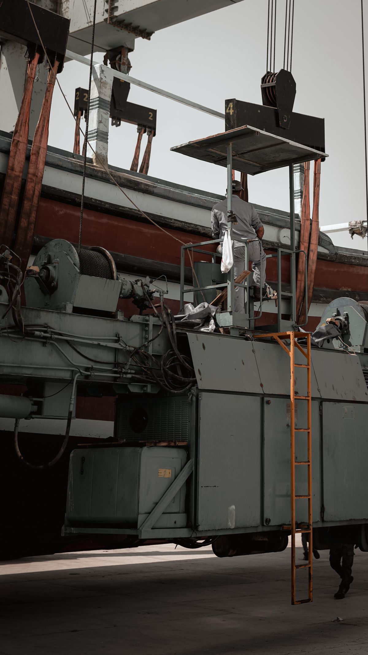 A worker servicing heavy industrial equipment