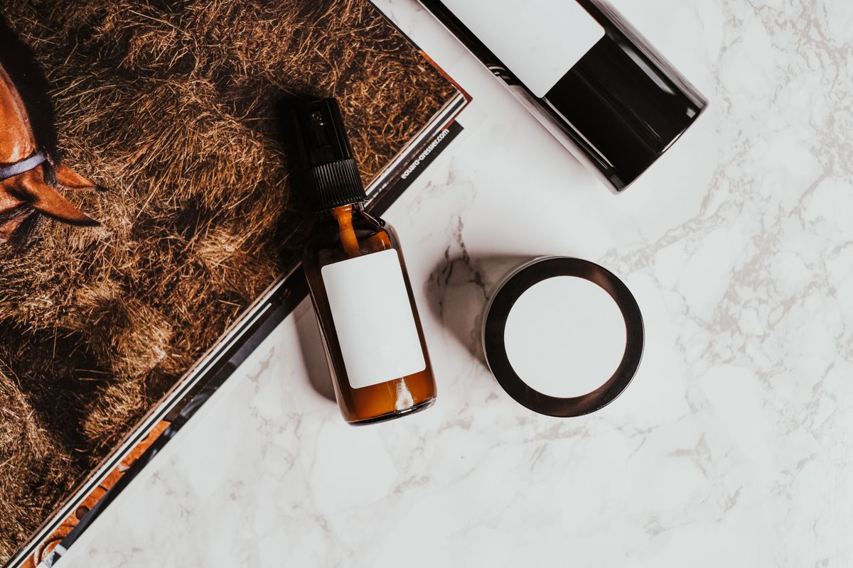 A serum bottle and a magazine on a marble surface