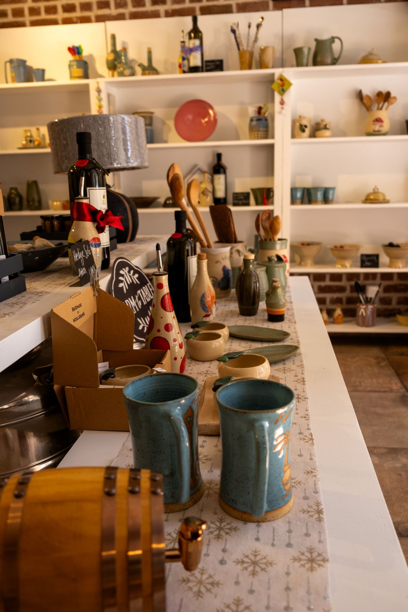 Shelves of pottery, mugs, and pantry goods inside the shop