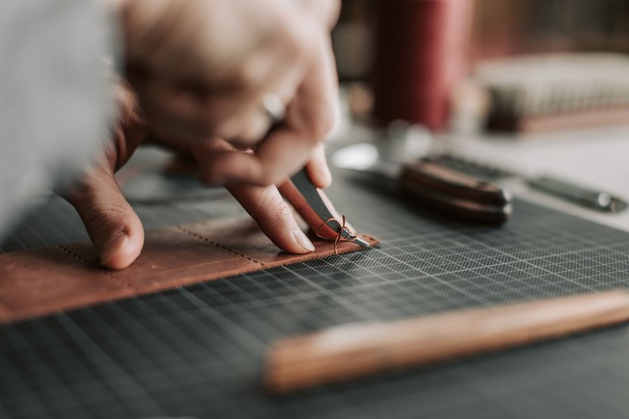 A maker working leather at a bench