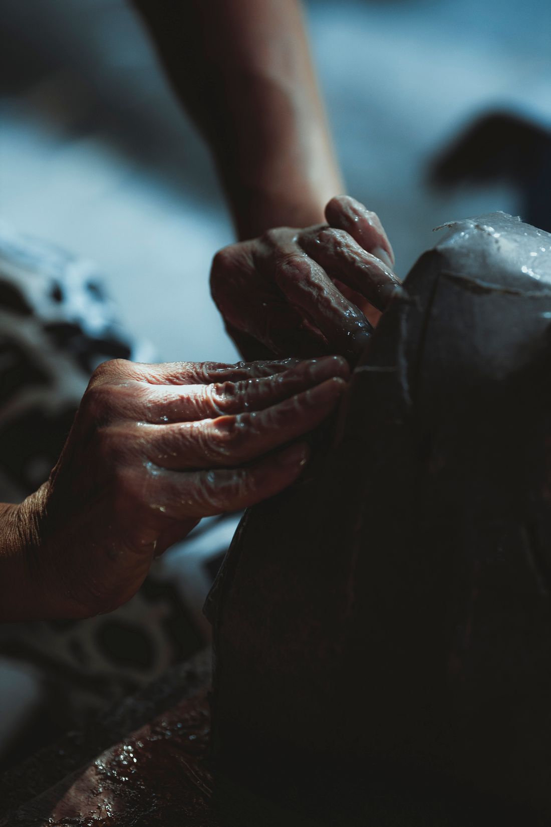 A potter shaping wet clay on a wheel