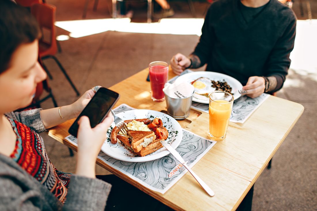 Barbecue plates served on butcher paper at a wooden table.