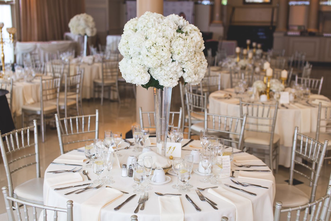 The Wrenwood's hall dressed for a wedding, with white florals and round tables